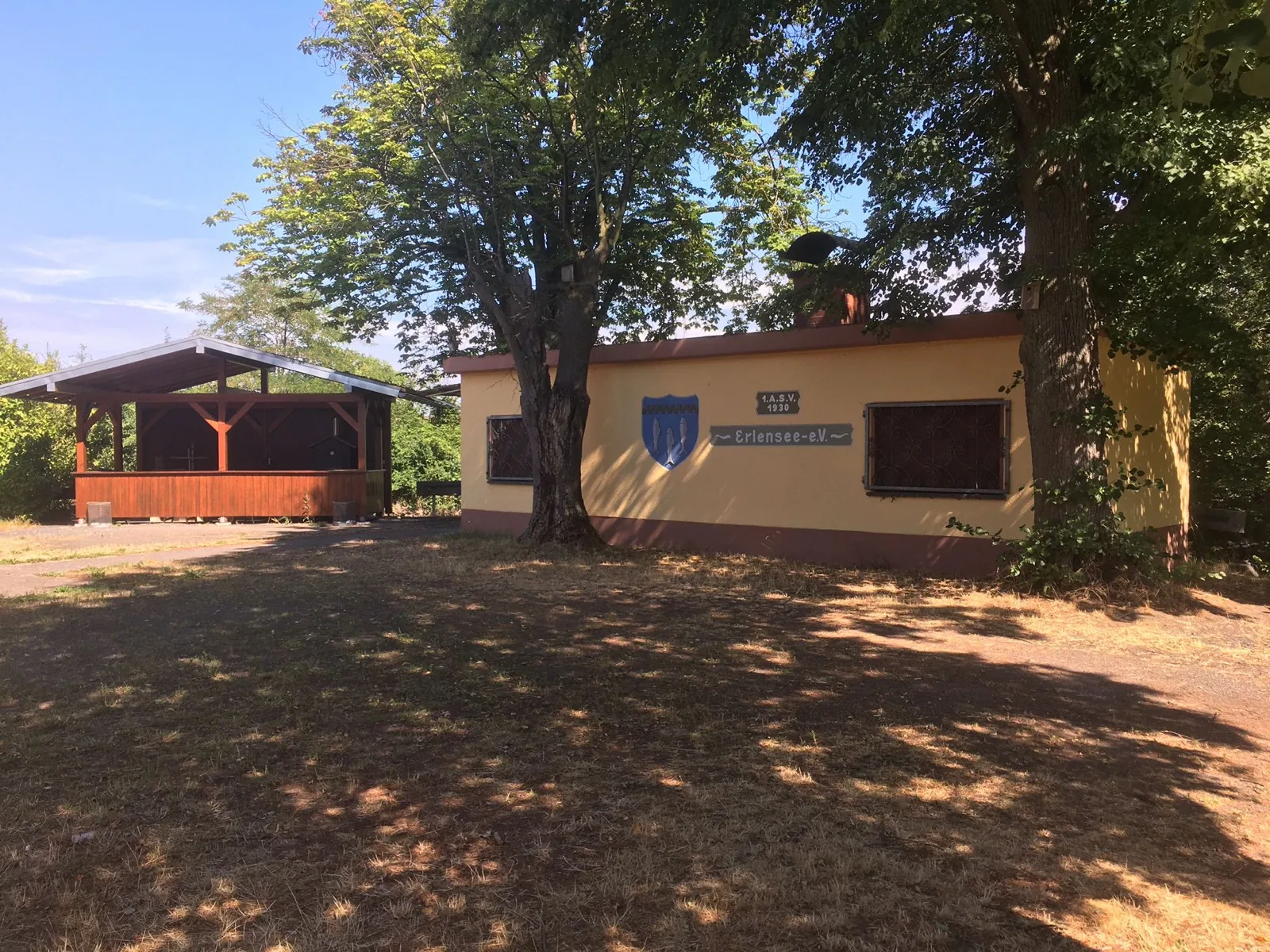 Vereinsheim mit Wappenwand und Pavillon